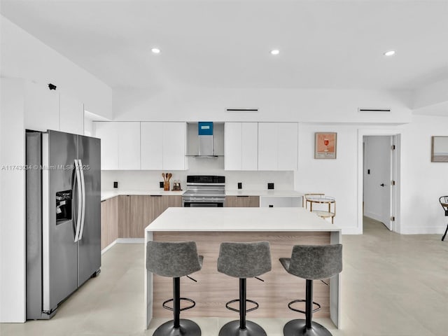 kitchen featuring recessed lighting, stainless steel appliances, light countertops, a kitchen bar, and modern cabinets