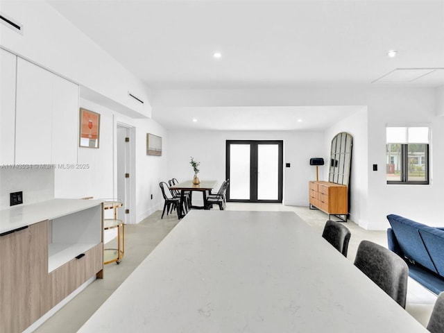 dining area with finished concrete flooring, visible vents, baseboards, recessed lighting, and french doors