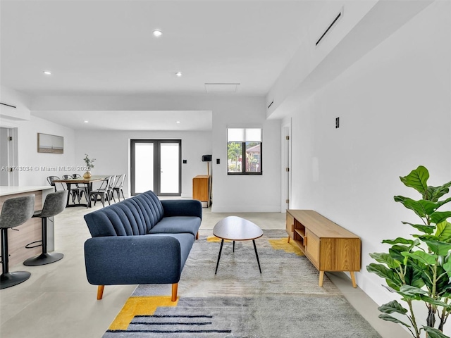 living area featuring visible vents, recessed lighting, and concrete flooring