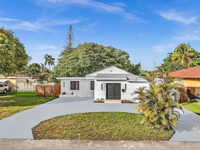 view of front of property featuring stucco siding, french doors, a front yard, and fence