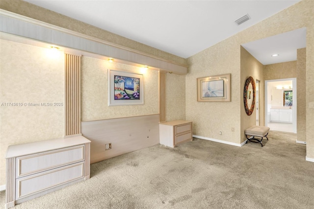 empty room featuring light colored carpet, visible vents, baseboards, and wallpapered walls