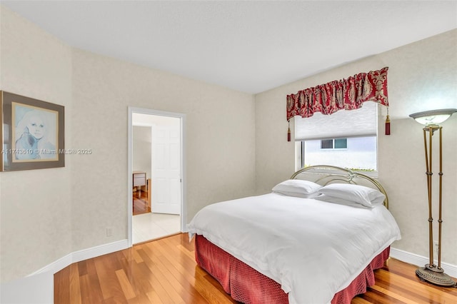 bedroom featuring baseboards and wood finished floors