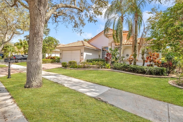 mediterranean / spanish home featuring a garage, driveway, a front lawn, and stucco siding