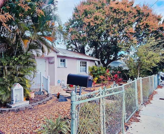 view of front of home with a gate, a fenced front yard, and stucco siding