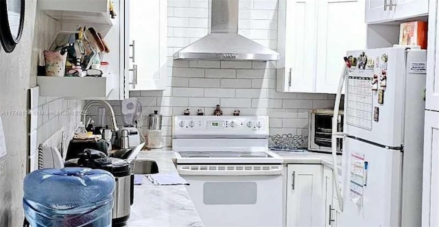 kitchen with backsplash, white appliances, white cabinetry, and wall chimney range hood