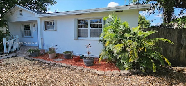 exterior space with fence and stucco siding