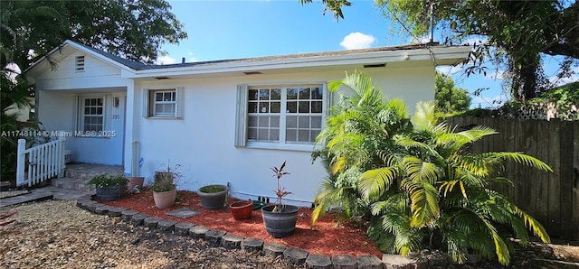 view of front of house featuring fence and stucco siding