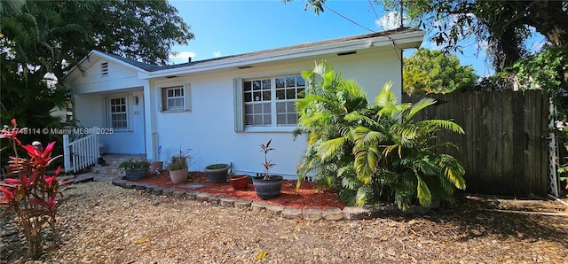 back of property with fence and stucco siding