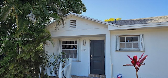 doorway to property featuring stucco siding