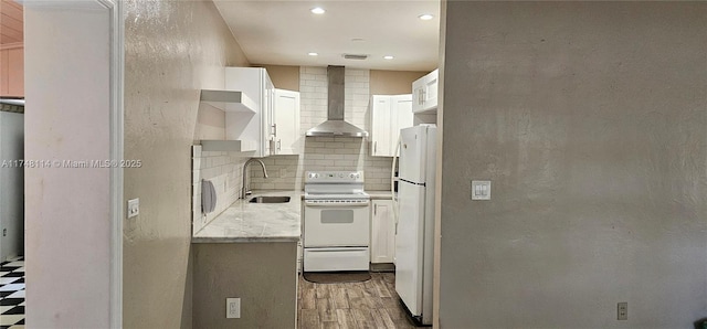 kitchen featuring decorative backsplash, a sink, light wood-style floors, wall chimney exhaust hood, and white appliances