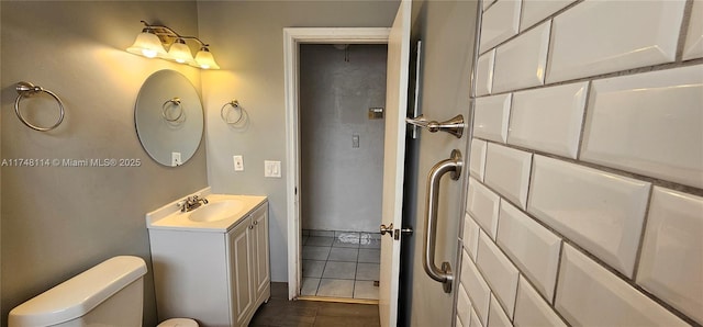 bathroom with toilet, tile patterned flooring, and vanity