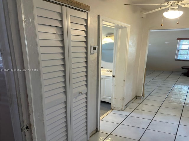 corridor with light tile patterned flooring and a sink