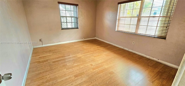 spare room featuring wood finished floors and baseboards
