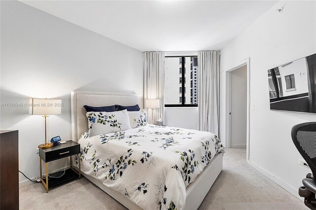 bedroom with baseboards and light colored carpet