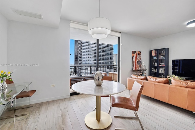 dining area featuring wood tiled floor, visible vents, and baseboards