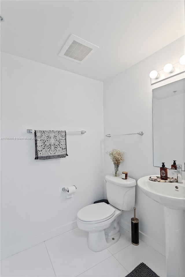 bathroom with toilet, baseboards, visible vents, and tile patterned floors