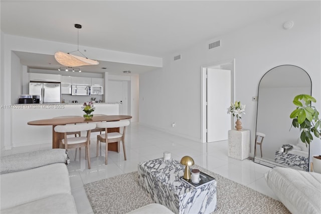 living room with baseboards, visible vents, and light tile patterned flooring