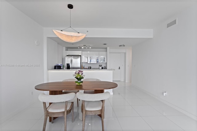 dining area with light tile patterned floors, visible vents, and baseboards