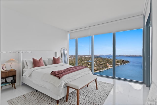 bedroom with a water view, light tile patterned floors, and floor to ceiling windows