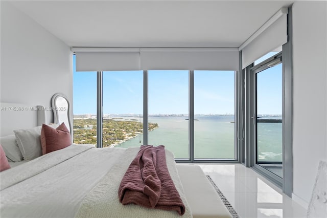 bedroom featuring a water view and light tile patterned flooring