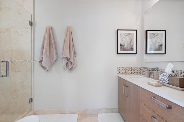 full bath featuring a stall shower, backsplash, and vanity