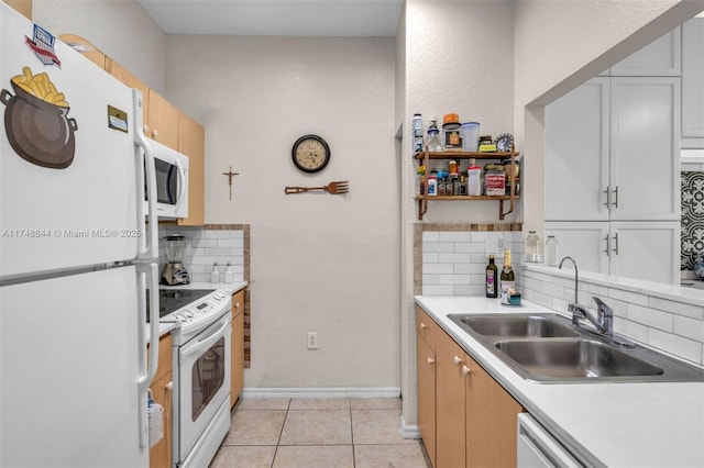 kitchen with light countertops, decorative backsplash, light tile patterned flooring, a sink, and white appliances