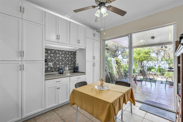 kitchen featuring white cabinetry, decorative backsplash, light countertops, and light tile patterned flooring