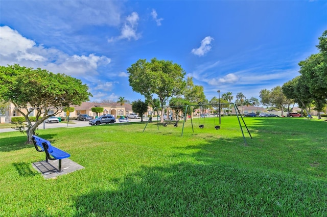 view of property's community featuring playground community and a lawn