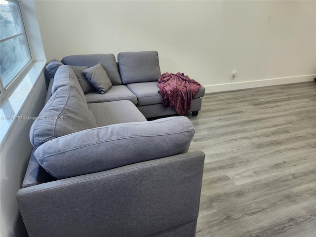 living area with light wood-style flooring and baseboards