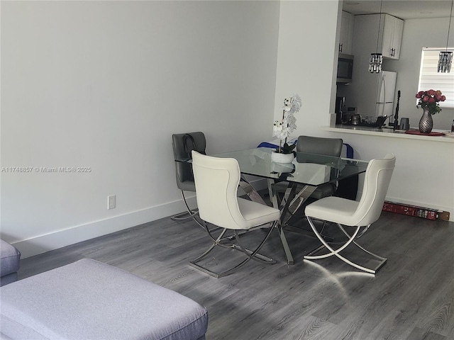 dining room with baseboards and wood finished floors