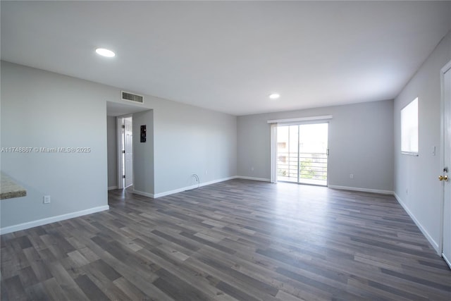 unfurnished room with recessed lighting, dark wood finished floors, visible vents, and baseboards