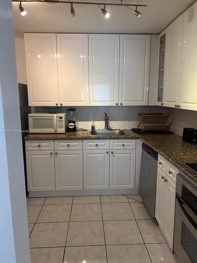 kitchen featuring stainless steel appliances, white cabinets, glass insert cabinets, and a sink