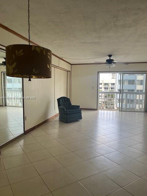 unfurnished room featuring ceiling fan, light tile patterned floors, and baseboards