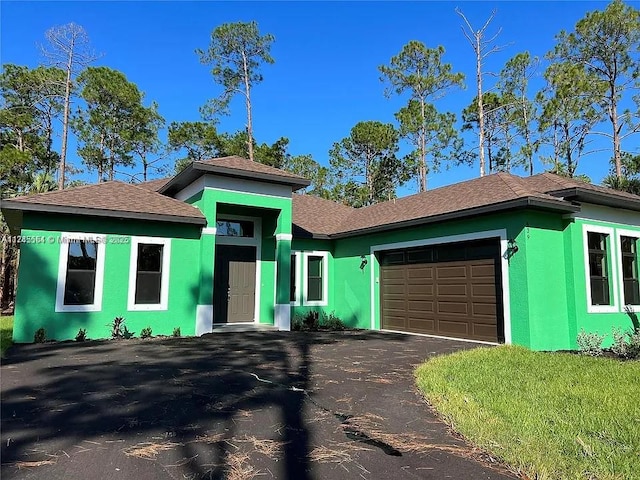 view of front of property with a garage, driveway, and stucco siding