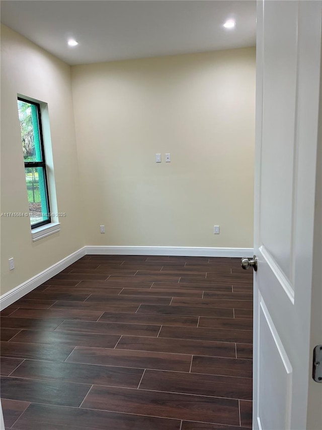 empty room with baseboards, dark wood finished floors, and recessed lighting