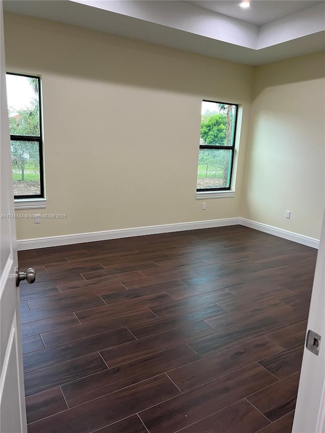 unfurnished room featuring recessed lighting, dark wood finished floors, and baseboards