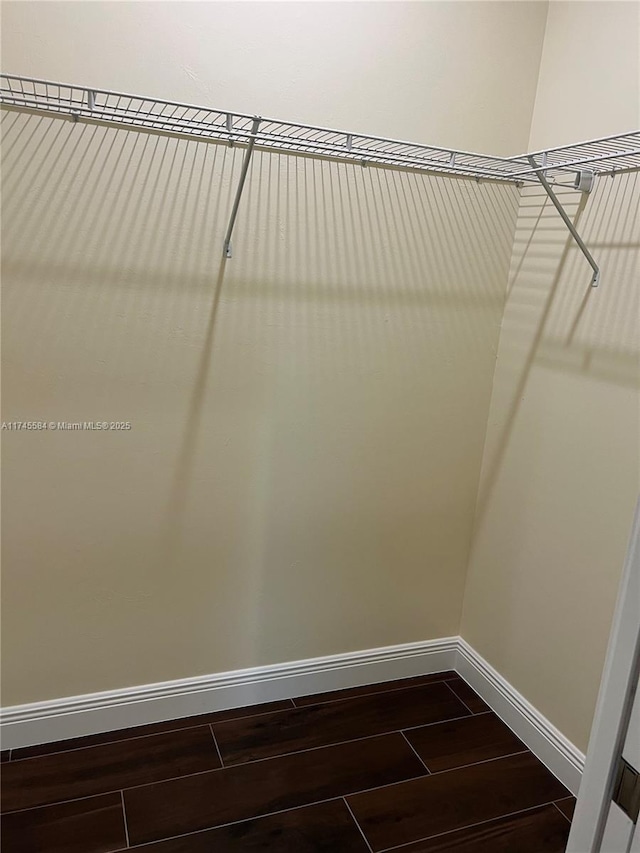 spacious closet with dark wood-style floors