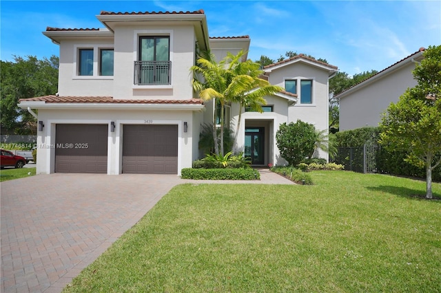 mediterranean / spanish-style house featuring a front lawn, decorative driveway, and stucco siding