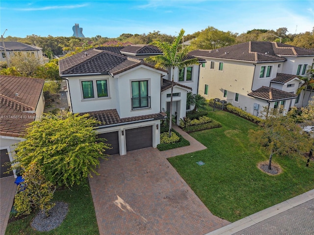 view of front facade with decorative driveway, a front yard, a tile roof, and a residential view