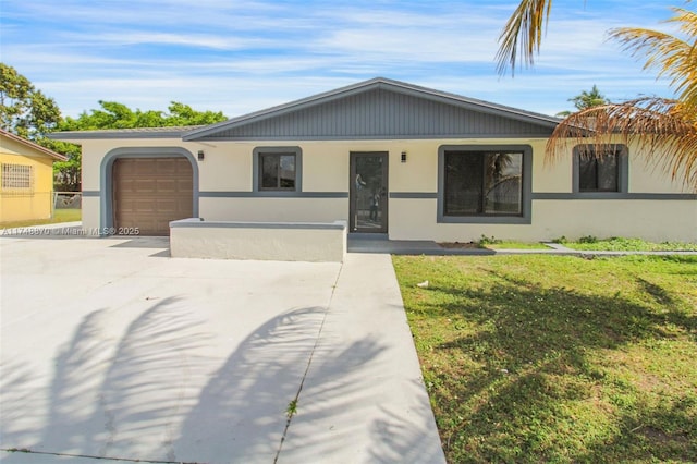 single story home featuring driveway, a garage, a front lawn, and stucco siding