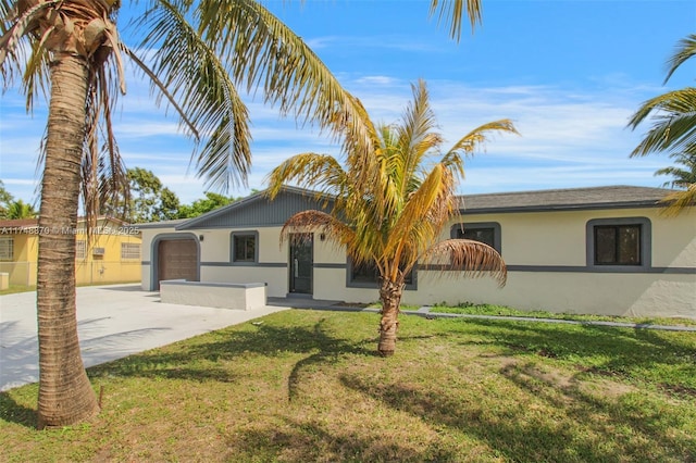 single story home featuring driveway, a front lawn, and stucco siding