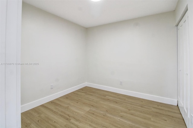 spare room with light wood-style floors and baseboards