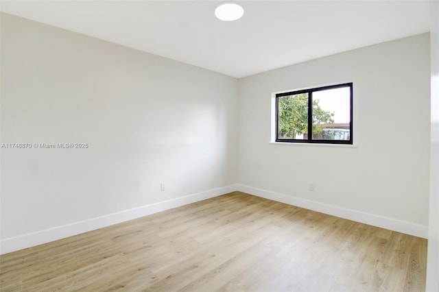 spare room with light wood-style flooring and baseboards