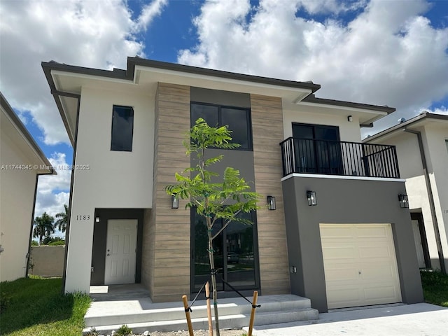 view of front of property with a balcony, a garage, and stucco siding