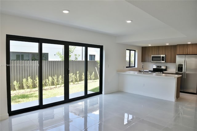 kitchen featuring modern cabinets, appliances with stainless steel finishes, a peninsula, light countertops, and recessed lighting