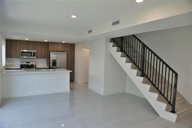 kitchen with appliances with stainless steel finishes, recessed lighting, light countertops, and visible vents