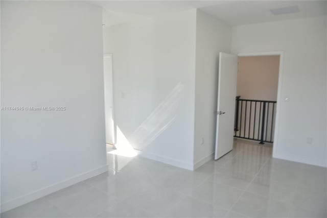 unfurnished room with baseboards