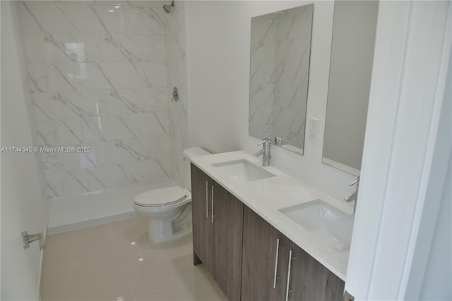 bathroom with double vanity, a stall shower, a sink, and toilet