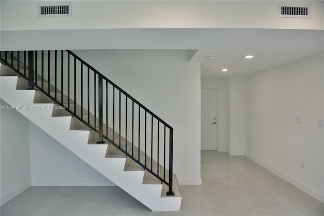 stairway with tile patterned floors, baseboards, visible vents, and recessed lighting