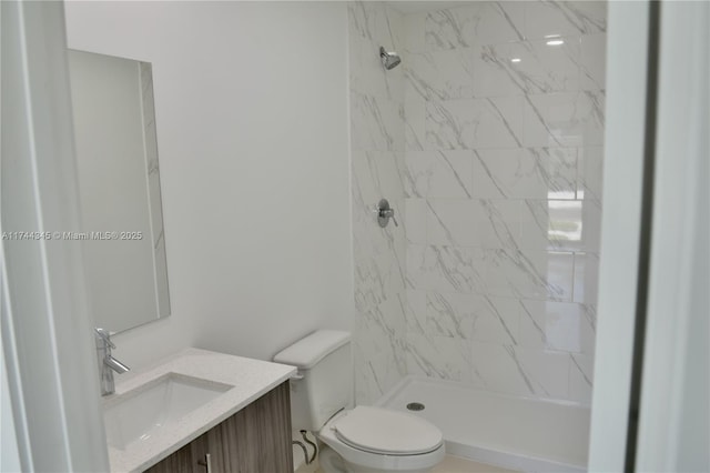 bathroom featuring toilet, a shower stall, and vanity